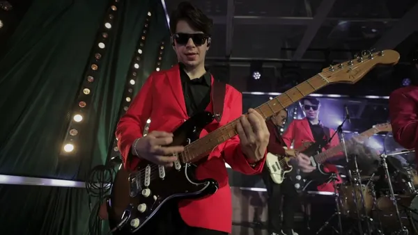 Гитарист Стиляги BAND в красном пиджаке на сцене